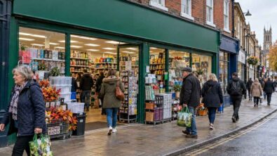 An open discount shop with a green fascia and shoppers on a British high street