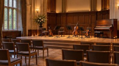An empty small concert hall with a piano and string instruments